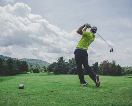 Golfer finishing a swing on a fairway